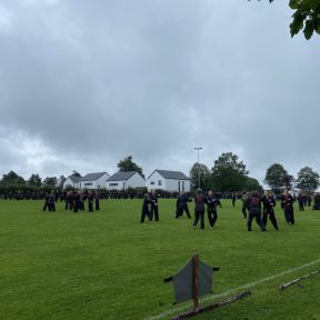 Fußballfeld mit dutzenden Menschen die Shinson Hapkido trainieren, im Vordergrund üben Schwarzgürtel.