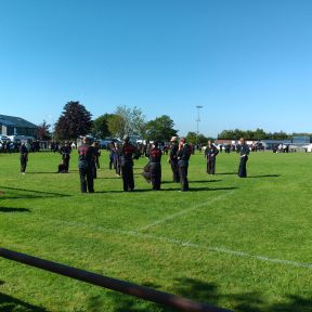 Fußballfeld mit dutzenden Menschen die Shinson Hapkido trainieren, im Vordergrund üben Blau-Rotgürtel.